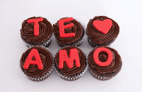 cupcakes with chocolate frosting and red letters saying te amo