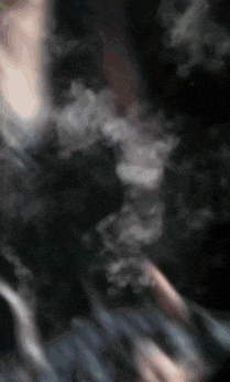 a person is smoking a hookah in a dark room .