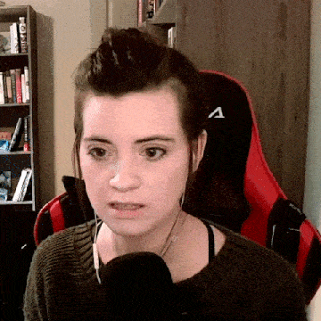 a woman wearing headphones and a green sweater is sitting in front of a red chair with the letter a on it .