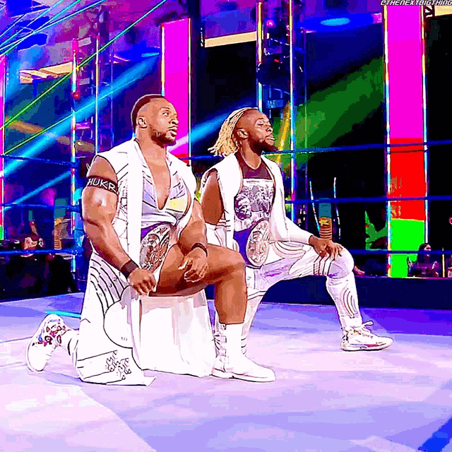 two wrestlers are kneeling down in a ring and one of them has the word hulk on his arm