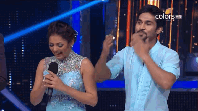 a man and a woman on a stage with the words colors hd on the bottom left