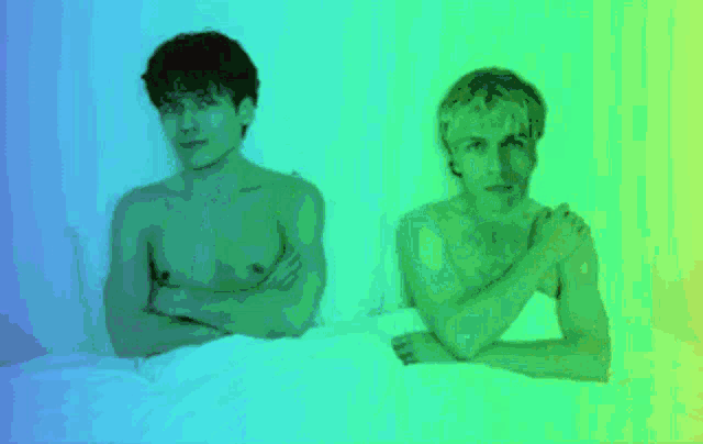 two shirtless men laying on a bed with their arms crossed in front of a green and blue background