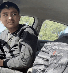 a man is sitting in the back seat of a car looking at something