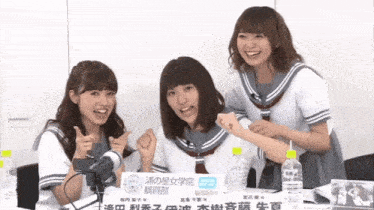 three girls in school uniforms are posing for a picture with a sign that says " action "