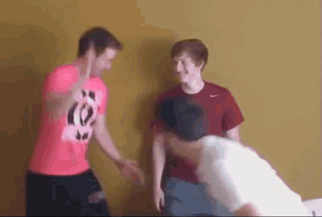 a group of young men are standing next to each other against a yellow wall .