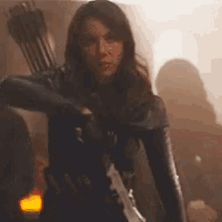 a woman is holding a bow and arrow and a knife .