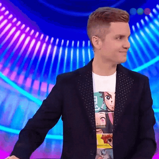 a man wearing a black jacket and a t-shirt with a cartoon face on it