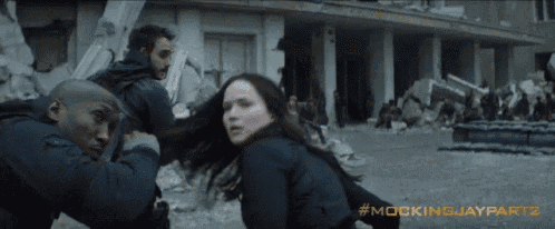 a group of people standing in front of a building with the words mockingjay part 2 written on the bottom
