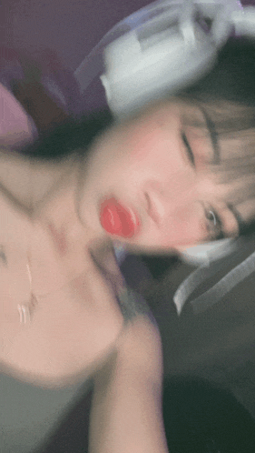 a blurry picture of a woman with red lips and headphones on