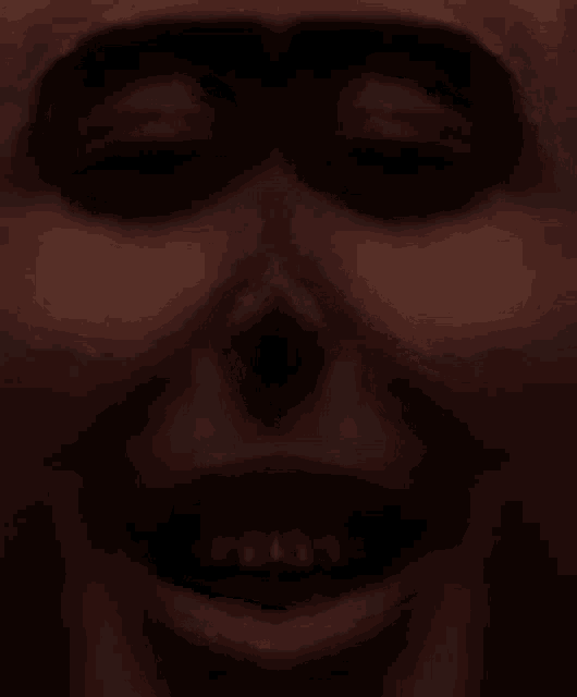 a close up of a person 's face with their eyes closed and a smile on their face .