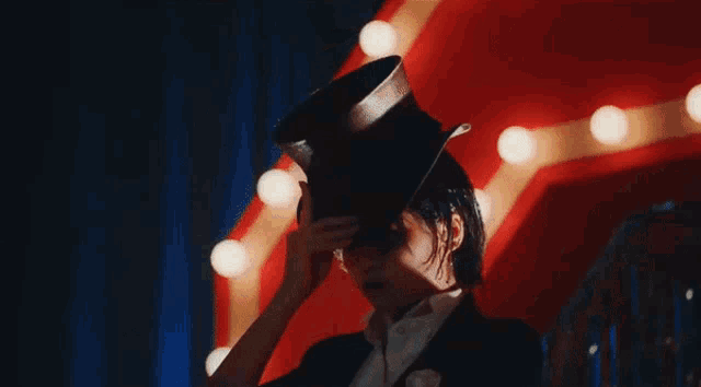 a woman in a tuxedo holds a cane in her hand