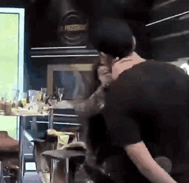 a man in a black shirt is carrying a woman in his arms