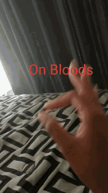 a person 's hand is laying on a bed with the words " on bloods " above it