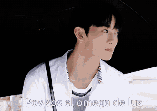 a young man is holding an umbrella with the caption pov sos el omega de luz