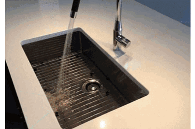 a stainless steel kitchen sink with water running from the faucet