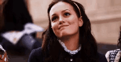 a woman is smiling while sitting in a crowd of people .