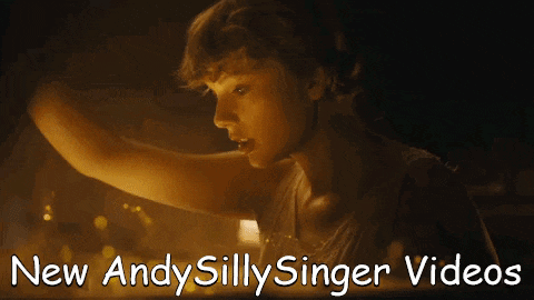 a woman in a dark room with the words " new andy silly singer videos " below her