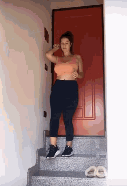 a woman is standing on a set of stairs in front of a red door .
