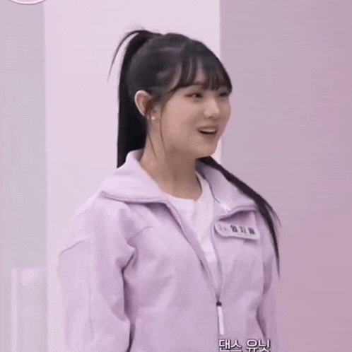 a girl in a ponytail is wearing a purple jacket