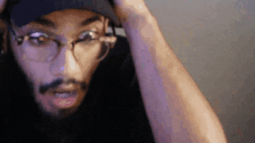 a close up of a man wearing glasses and a hat