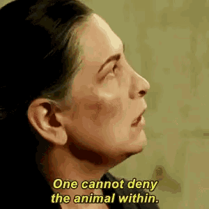 a close up of a woman 's face with a yellow caption that says `` one cannot deny the animal within . ''