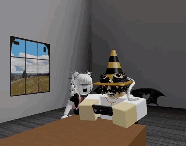 a boy with a cone on his head is sitting at a table with a girl