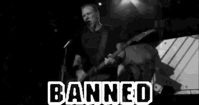 a black and white photo of a man playing a guitar and singing into a microphone with the words banned in white letters .