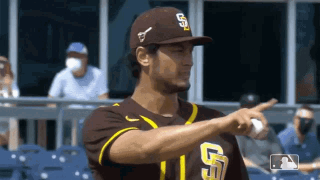 a baseball player wearing a san diego padres uniform is pointing