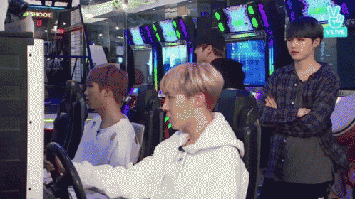 a group of young men are playing a video game in an arcade with a sign that says shoot on it