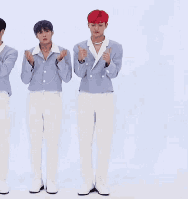 a man in a blue jacket and white pants stands next to another man with red hair