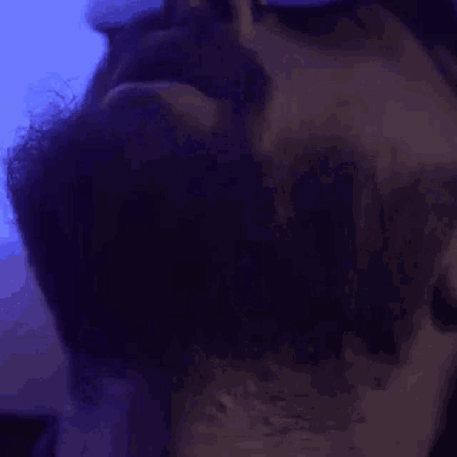 a man wearing sunglasses and a mask is looking at the camera in a blurry photo .