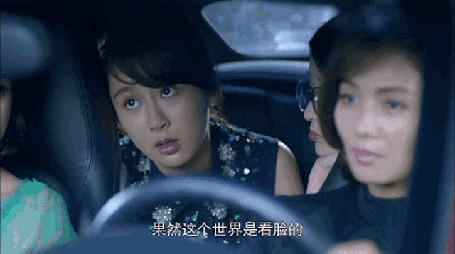 three women are sitting in a car with chinese writing on the side