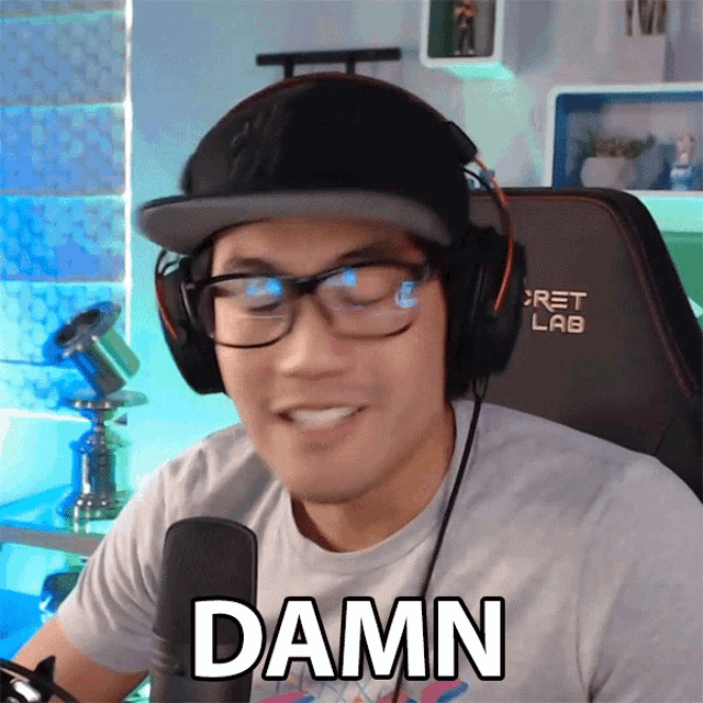 a man wearing headphones and glasses says the word damn