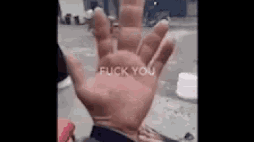 a close up of a hand with the words `` fuck you '' written on it .