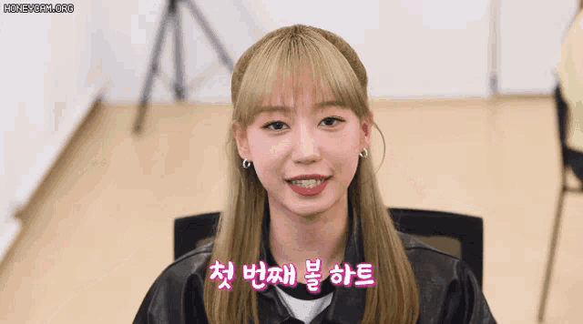a girl with korean writing on her face smiles for the camera