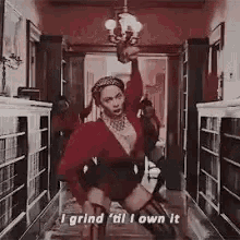 a woman in a red dress is dancing in a hallway while holding a gun .