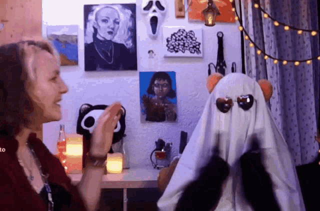 a woman clapping in front of a ghost with sunglasses on