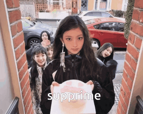 a girl holding a cake with the word supreme on it