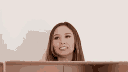 a woman is making a funny face while sitting in front of a laptop .