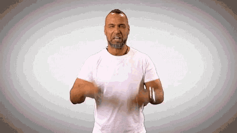 a man with a beard is wearing a white shirt and making a funny face
