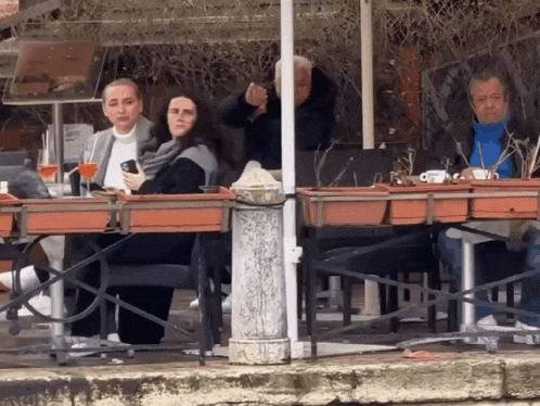 a group of people are sitting at a table with a sign that says ' a ' on it