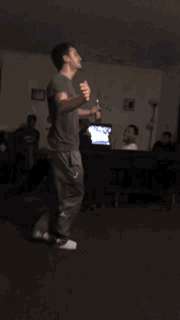 a man is dancing in a living room in front of a tv