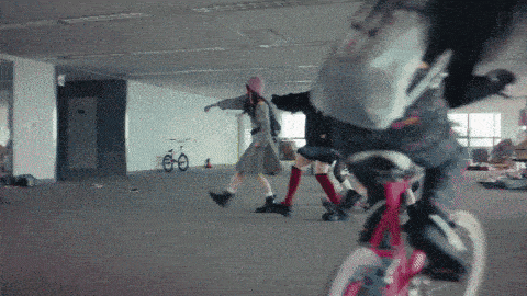 a person riding a bike in an empty room with other people