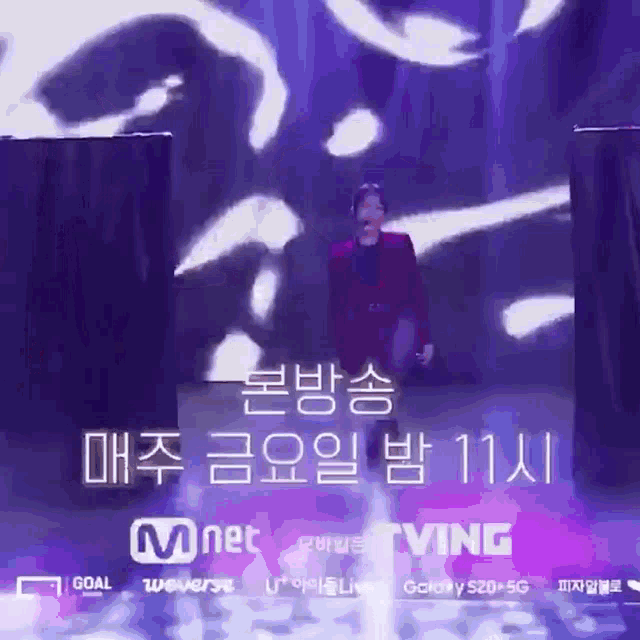 a man in a purple suit is walking on stage