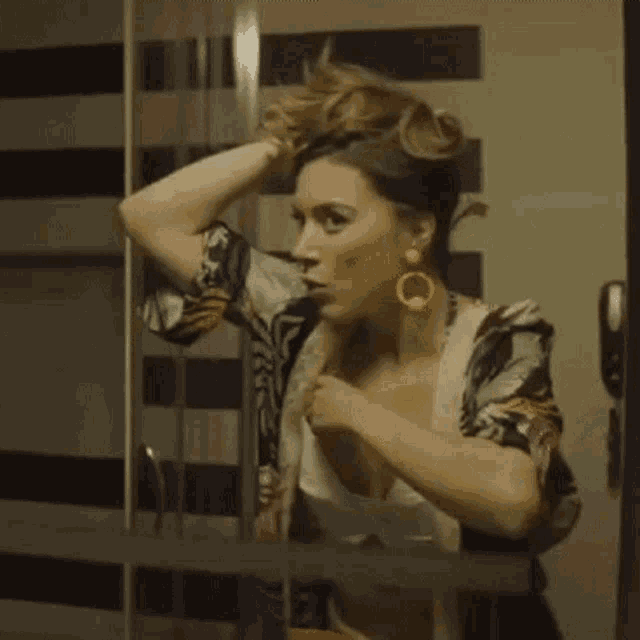 a woman is looking at herself in a mirror .