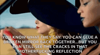 three women are sitting in a car and one of them is holding a broken mirror back together .