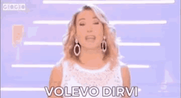 a woman in a white dress is holding a sign that says `` vi amo '' .