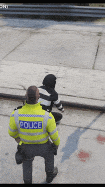 a police officer is standing next to a man in a black and white striped shirt