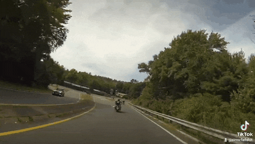a man is riding a motorcycle down a road .