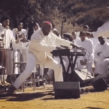 a man playing a keyboard in front of a crowd of people